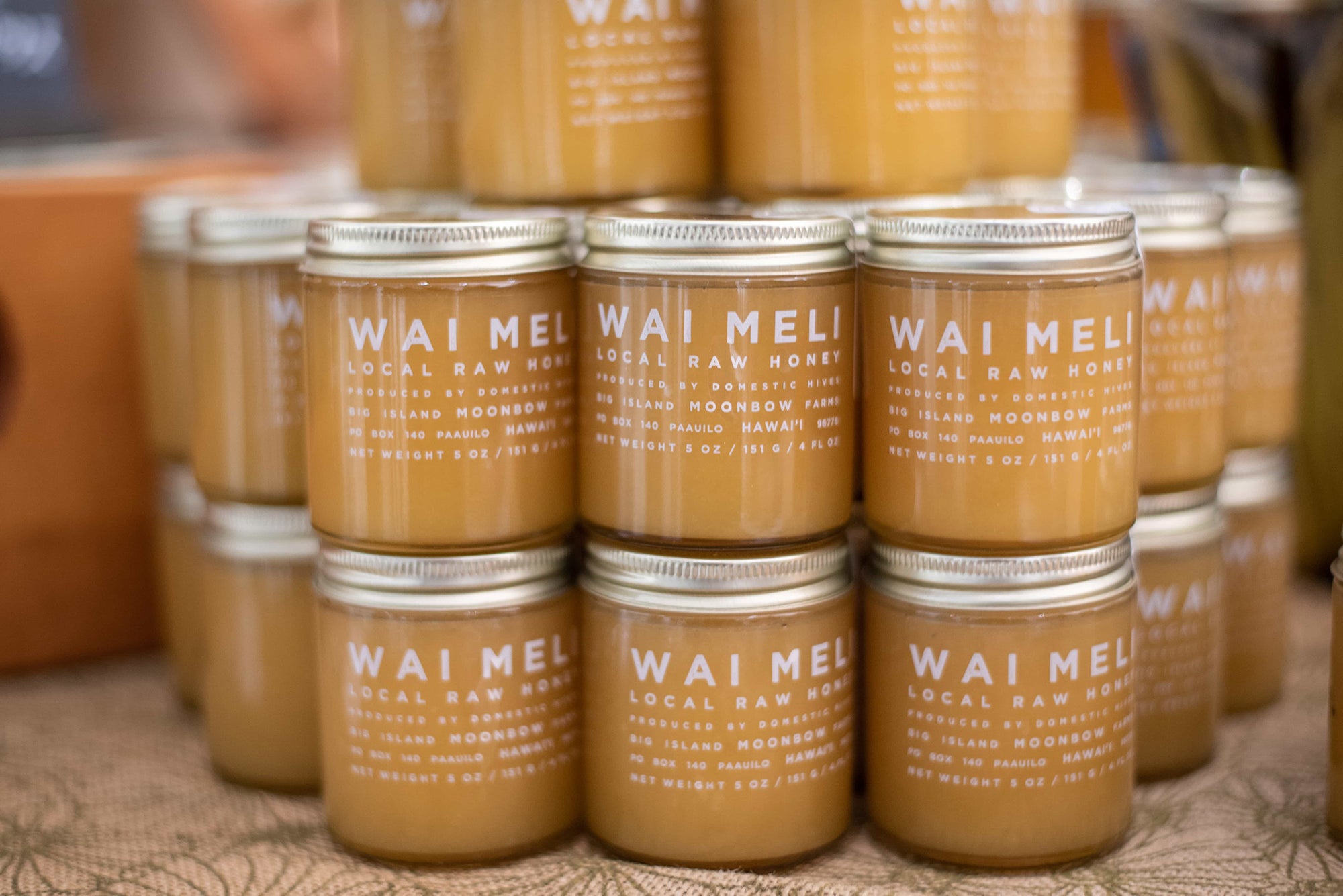 Multiple stacked jars of Wai Meli Local Raw Honey