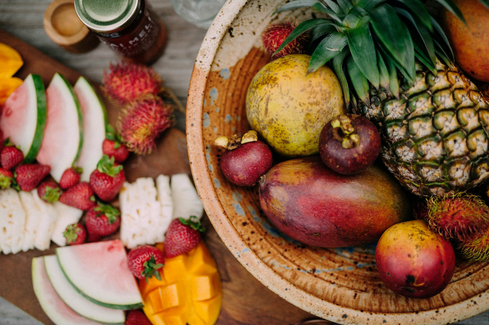 Assortment of fruit in a bowl and cut up beside the bowl
